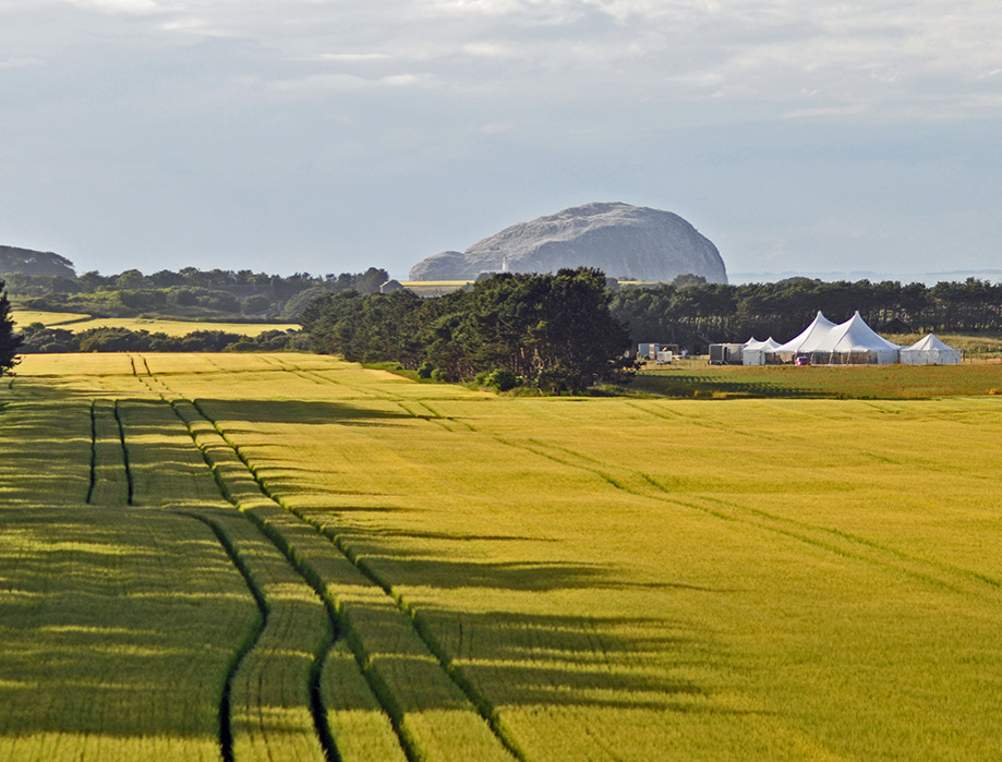 Fields and hills surrounding the site with a marquee in the distance
